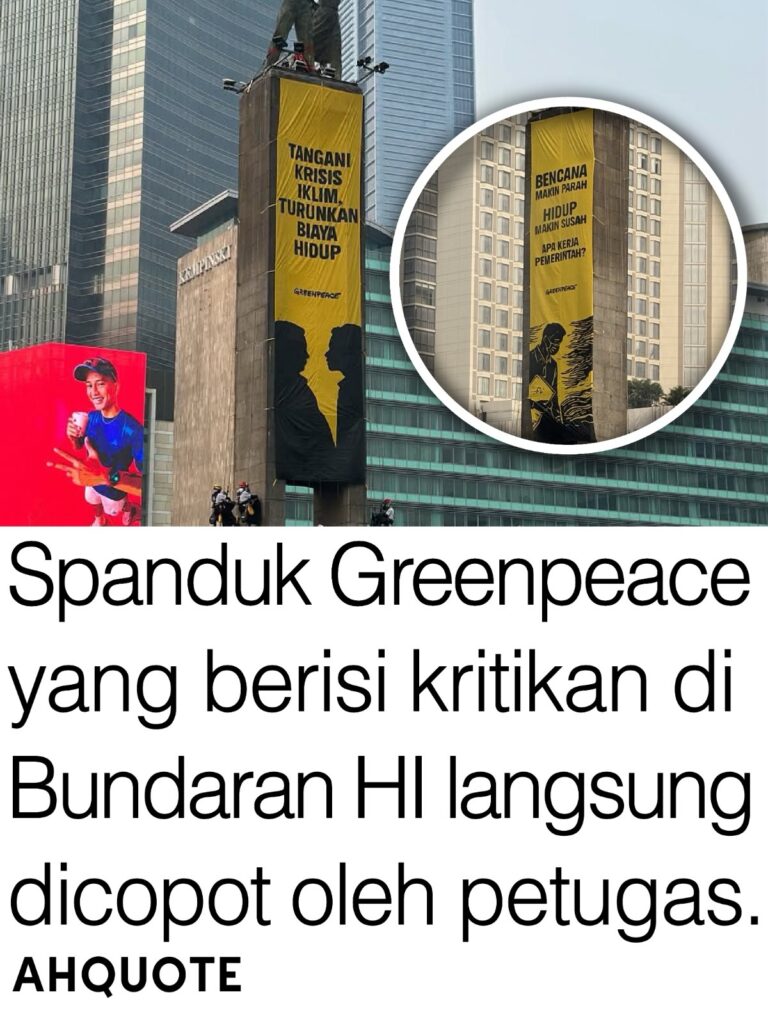 Aktivis Greenpeace membentangkan spanduk kritik di Bundaran HI